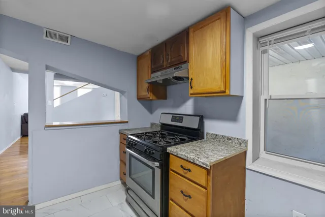 a kitchen with granite countertop a stove and a refrigerator