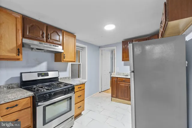 a kitchen with stainless steel appliances granite countertop a stove and a refrigerator