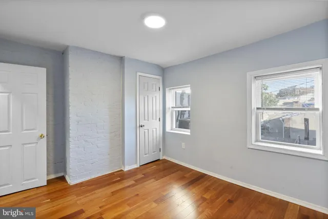 a view of empty room with window and wooden floor
