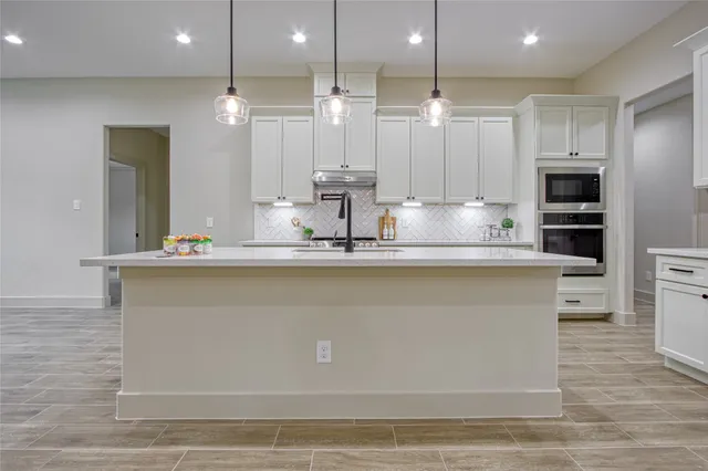 a kitchen with kitchen island granite countertop wooden cabinets and a refrigerator