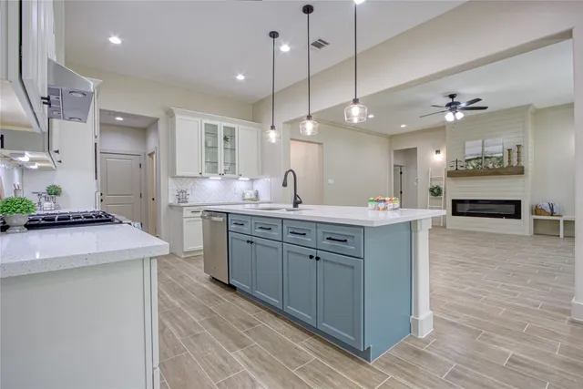 a large kitchen with kitchen island a sink stainless steel appliances and cabinets