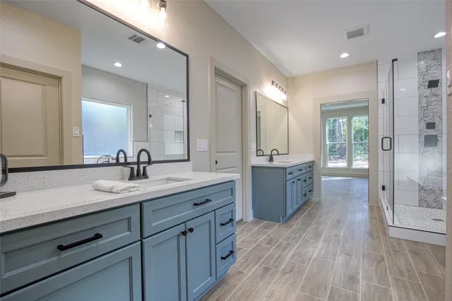a spacious bathroom with a granite countertop sink mirror and shower