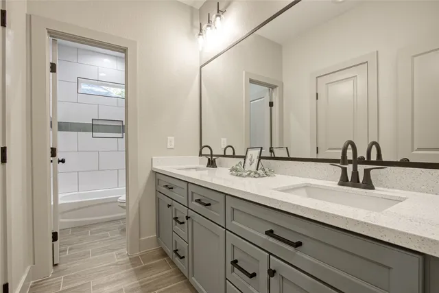 a bathroom with double sink and a mirror