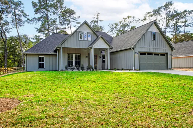 a front view of a house with yard and green space