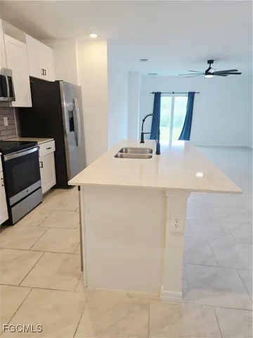 a kitchen with stainless steel appliances a refrigerator sink and cabinets