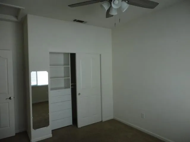 an empty room and a chandelier fan