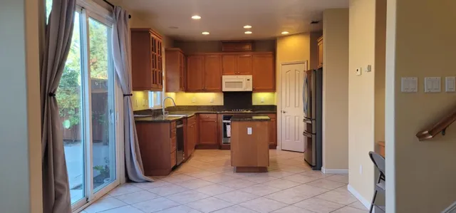 a kitchen with granite countertop a refrigerator and a sink