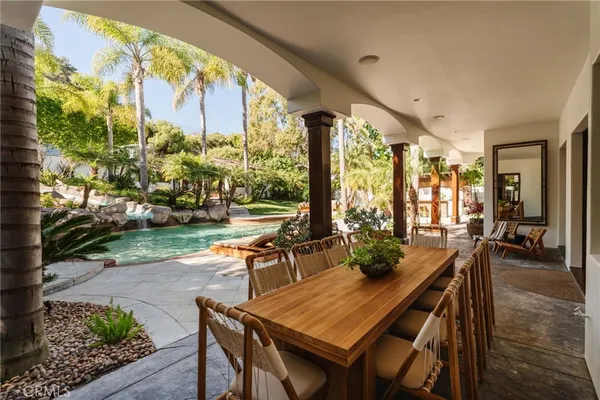 a view of a backyard with table and chairs potted plants and palm tree