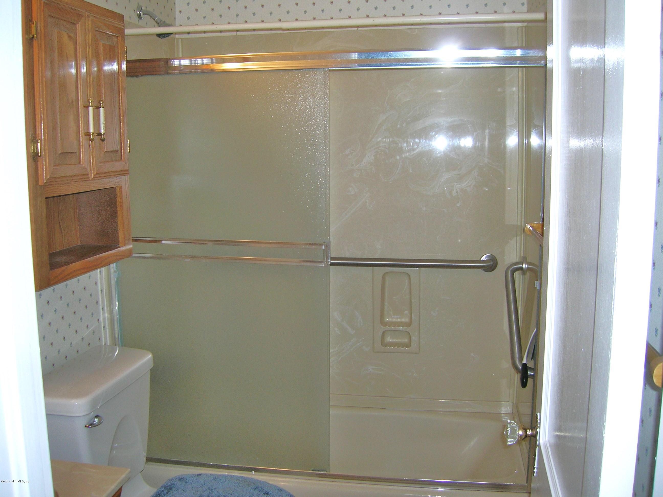 4648 Manchester Road Jacksonville, FL 32210 - Photo 9 of 16 a bathroom with a glass shower door