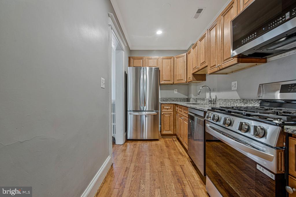 2406 37th Street Northwest Washington, DC 20007 - Photo 23 of 44 a kitchen with a stove a sink and a refrigerator