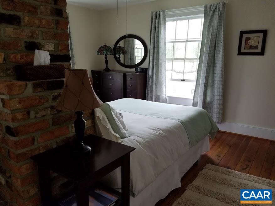 27 Chapel Hollow Road Afton, VA 22920 - Photo 18 of 22 a bedroom with a bed a mirror and a window