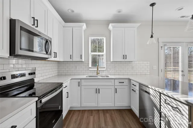 a view of a kitchen with wooden floor and a ceiling fan