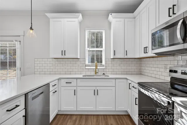 a kitchen with white cabinets appliances and a sink
