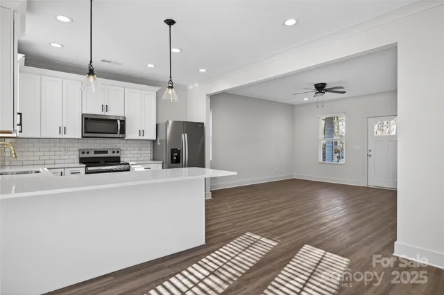 a kitchen with stainless steel appliances a stove top oven a sink a refrigerator a center island and cabinets