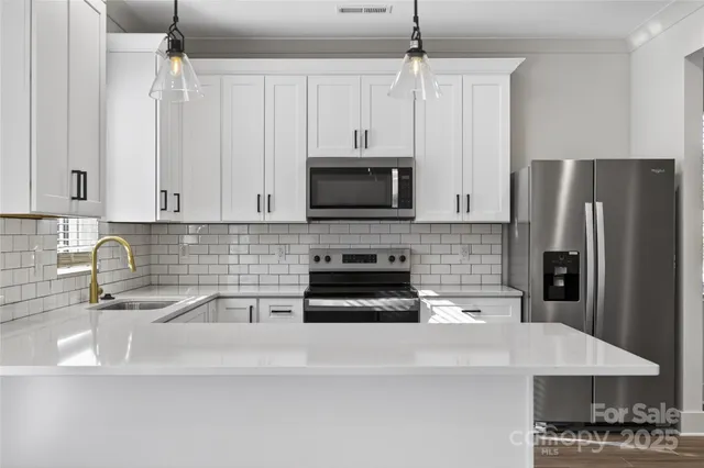 a view of a kitchen with a sink and dishwasher with wooden floor