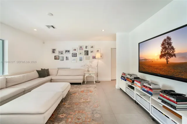 a living room with furniture and a floor to ceiling window