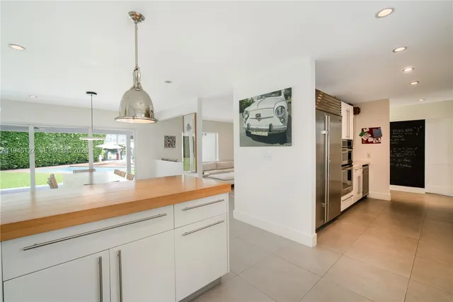 a view of swimming pool with lawn chairs and large trees