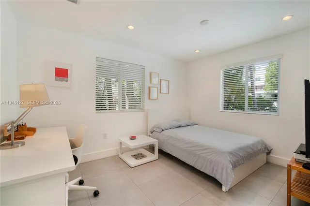 a front view of a house with garden and tree