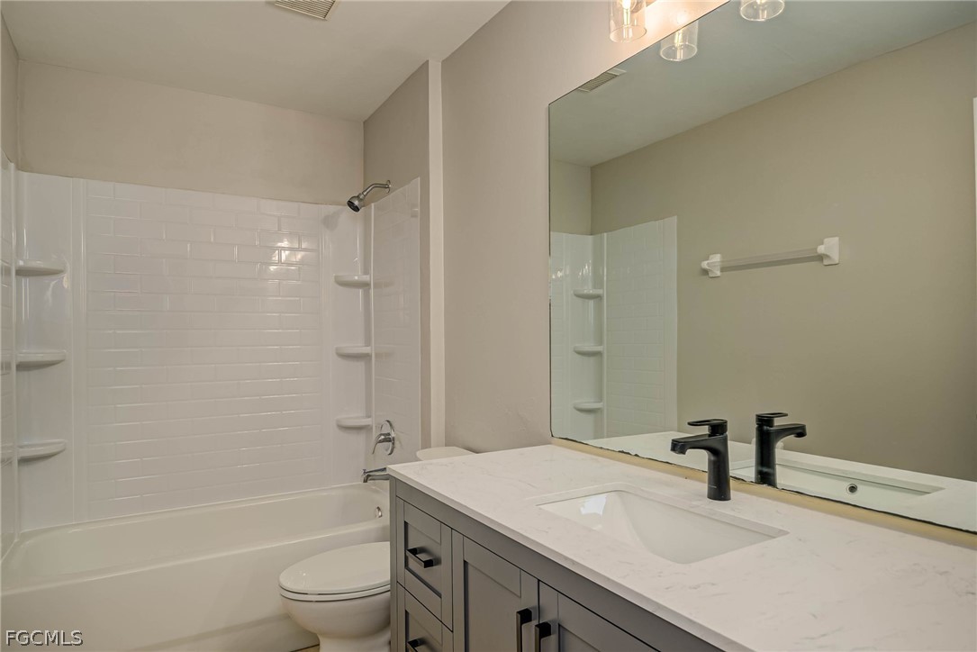 704 Ichabod Avenue Lehigh Acres, FL 33973 - Photo 11 of 22 a bathroom with a sink a toilet and shower