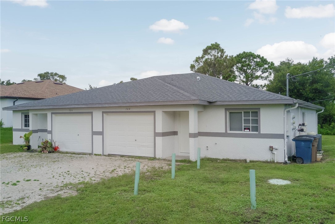 704 Ichabod Avenue Lehigh Acres, FL 33973 - Photo 2 of 22 a view of a house with a garden