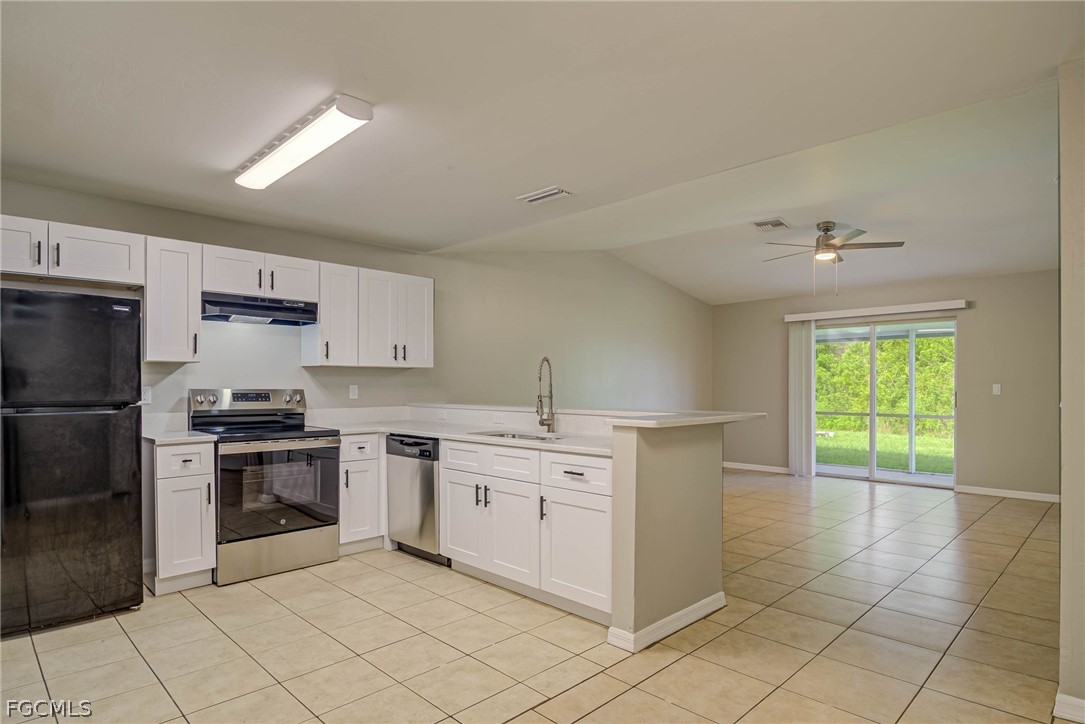 704 Ichabod Avenue Lehigh Acres, FL 33973 - Photo 3 of 22 a kitchen with stainless steel appliances a stove sink and cabinets