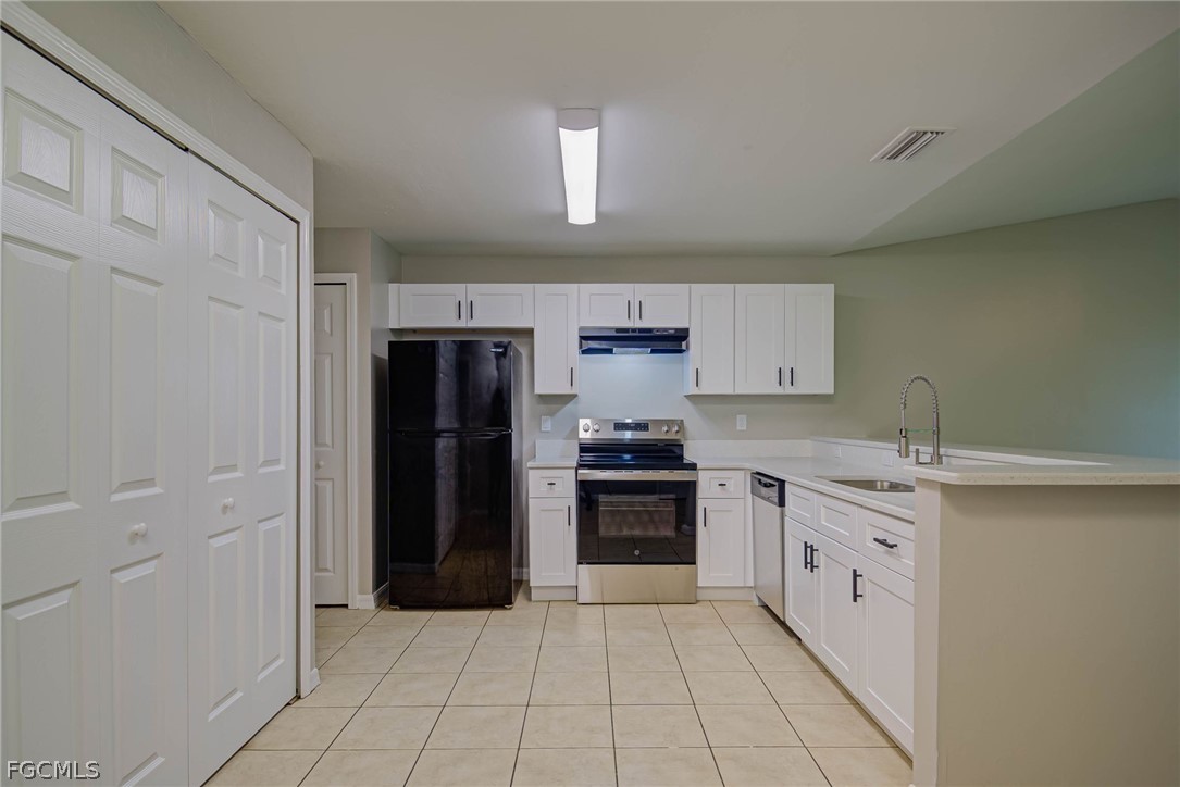 704 Ichabod Avenue Lehigh Acres, FL 33973 - Photo 6 of 22 a kitchen with stainless steel appliances granite countertop a refrigerator and a sink