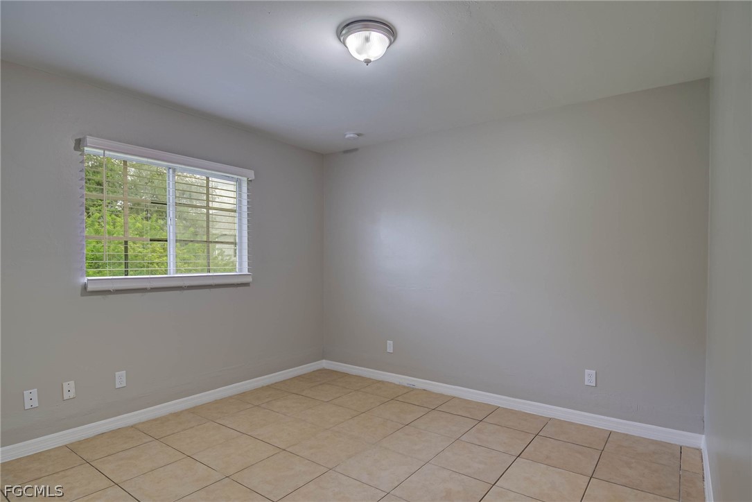 704 Ichabod Avenue Lehigh Acres, FL 33973 - Photo 9 of 22 en empty room with windows