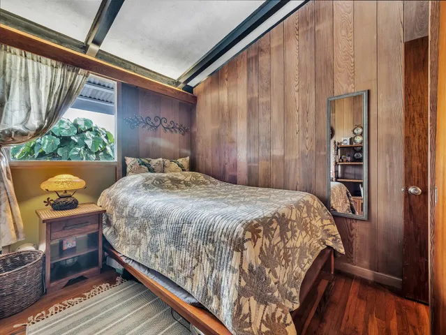 a bedroom with a bed and a dresser next to a window