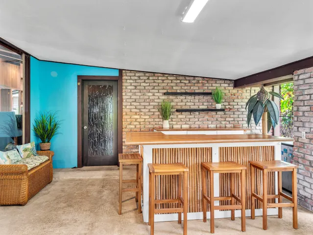 a living room with furniture a flat screen tv and floor to ceiling window