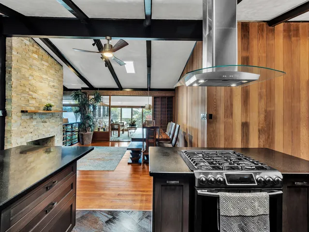 a kitchen with stainless steel appliances granite countertop a stove a sink dishwasher and cabinets with wooden floor