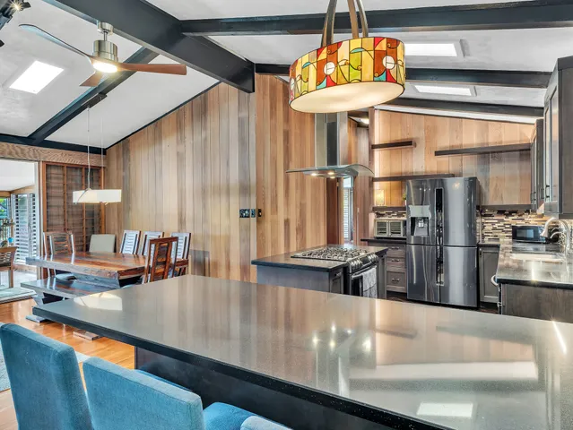 a kitchen with stainless steel appliances granite countertop a sink and a refrigerator