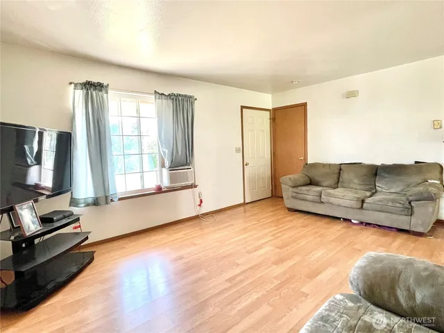 a view of an empty room with wooden floor