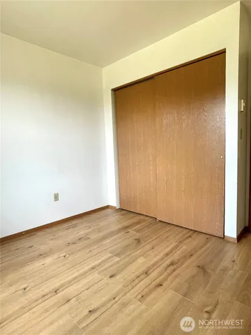 an empty room with wooden floor and closet
