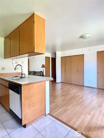 a view of a living room and kitchen with furniture and wooden floor