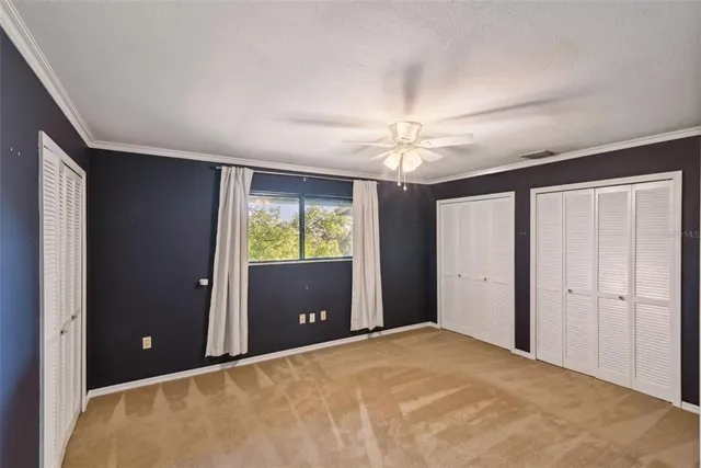 a view of a big room with closet and chandelier fan