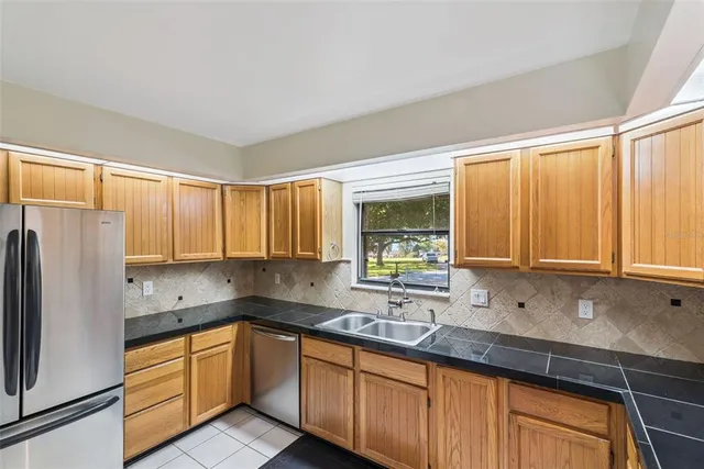 a kitchen with stainless steel appliances sink refrigerator and window