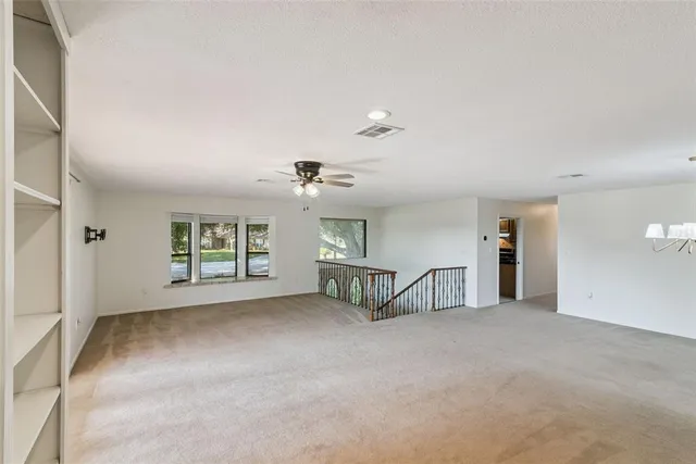 an empty room with windows and cabinet