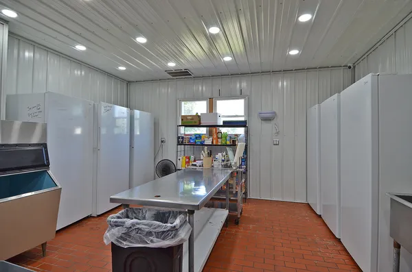 a kitchen with stainless steel appliances granite countertop a refrigerator a sink and a stove with wooden floor