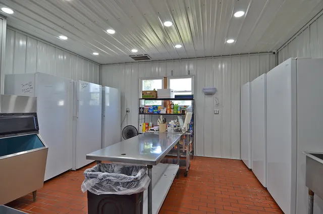 a kitchen with stainless steel appliances granite countertop a refrigerator a sink and a stove with wooden floor