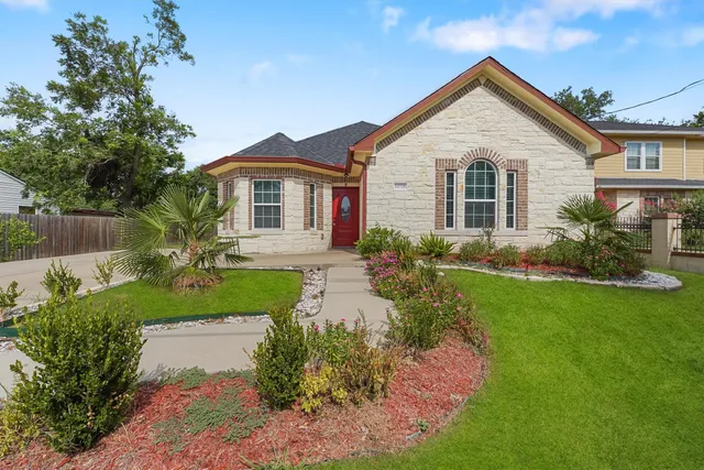 a front view of a house with a garden
