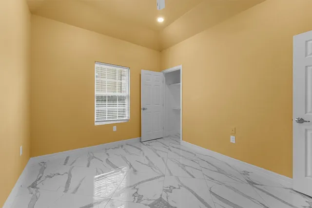 a view of a big room with wooden floor and windows