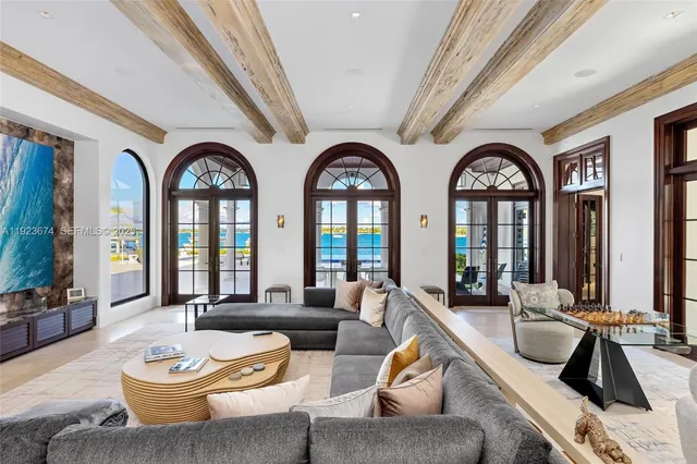 a living room with furniture a large window and potted plants