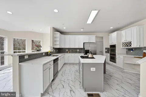 a large white kitchen with cabinets