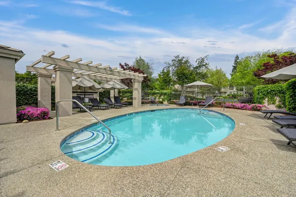 a view of a swimming pool with an outdoor seating and a garden