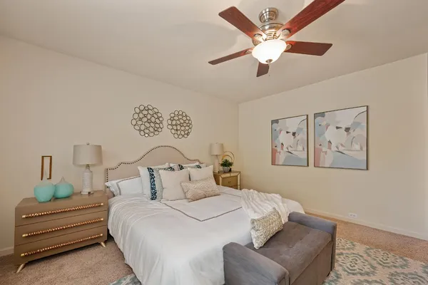 a bedroom with a large bed couch and a window