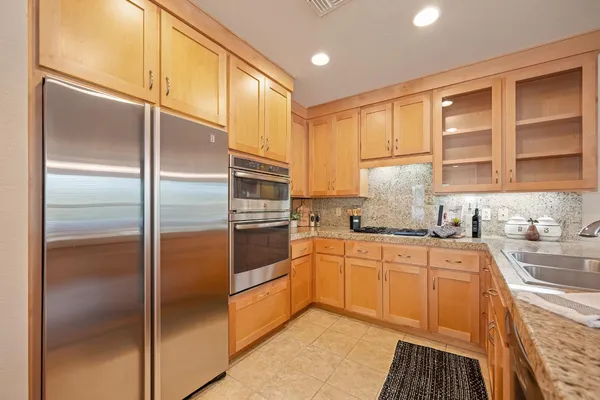 a kitchen with stainless steel appliances granite countertop a refrigerator and a sink