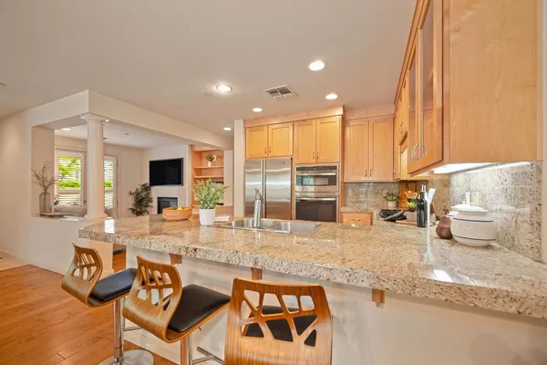 a dining hall with stainless steel appliances granite countertop a sink and a microwave