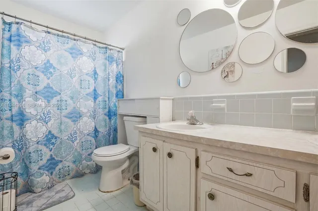 a bathroom with a granite countertop sink a toilet and a mirror
