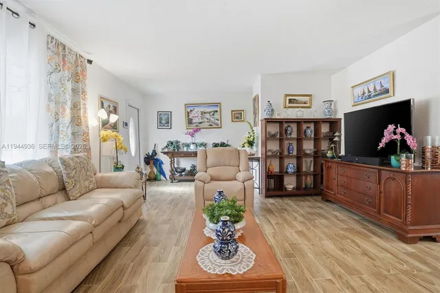 a living room with furniture a bookshelf and a window