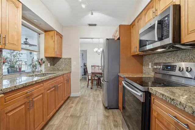 a kitchen with stainless steel appliances granite countertop a stove a sink and a microwave